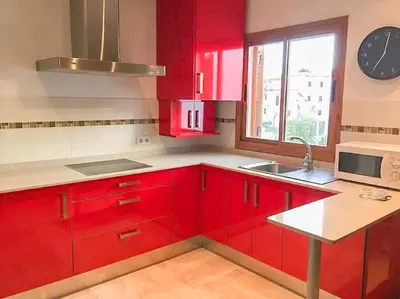 a red kitchen with a sink and a microwave at Precioso apartamento a 700 m del mar in Chiclana de la Frontera