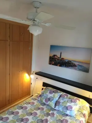 a bedroom with a bed and a painting on the wall at Precioso apartamento a 700 m del mar in Chiclana de la Frontera