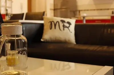 a glass bottle sitting on a table with a couch at Precioso apartamento a 700 m del mar in Chiclana de la Frontera