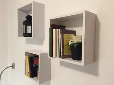 a white book shelf with books and a potted plant at Precioso apartamento a 700 m del mar in Chiclana de la Frontera