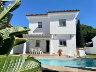 a house with a swimming pool in front of it at Chalet Edén Azul in Chiclana de la Frontera