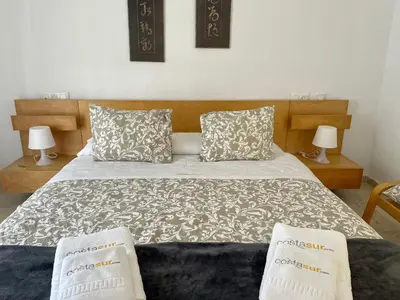 a bedroom with a large bed with two pillows at Chalet Edén Azul in Chiclana de la Frontera