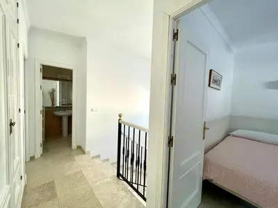 a hallway with a bed and a sink in a room at Chalet Edén Azul in Chiclana de la Frontera