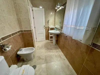 a bathroom with a toilet and a sink and a shower at Chalet Edén Azul in Chiclana de la Frontera
