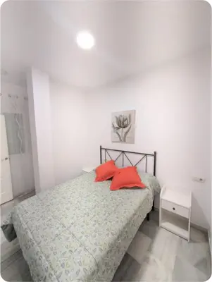 a bedroom with a bed with two red pillows on it at Puerto Luxury Centro in El Puerto de Santa María