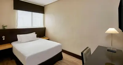 a small room with a bed and a table at NH Avenida Jerez in Jerez de la Frontera