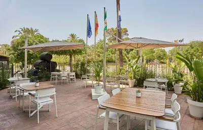 a patio with tables and chairs and umbrellas at NH Avenida Jerez in Jerez de la Frontera