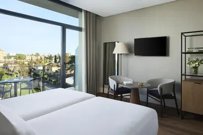 a hotel room with a bed and a large window at NH Avenida Jerez in Jerez de la Frontera