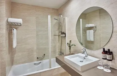 a bathroom with a sink and a shower and a mirror at NH Avenida Jerez in Jerez de la Frontera