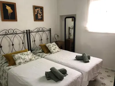 two beds in a bedroom with two green pillows on them at Gran casa con balcón para grupos en centro histórico in El Puerto de Santa María
