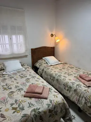 two beds sitting next to each other in a bedroom at Gran casa con balcón para grupos en centro histórico in El Puerto de Santa María
