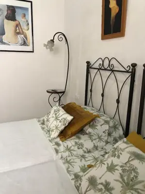 a bedroom with a bed with a black frame at Gran casa con balcón para grupos en centro histórico in El Puerto de Santa María