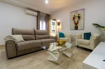 a living room with a couch and a glass table at SH Piluca's Home. Moderno apartamento con patio in Cádiz