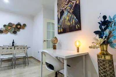 a room with a white desk and a painting on the wall at SH Piluca's Home. Moderno apartamento con patio in Cádiz