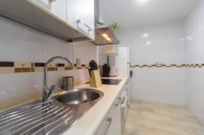 a kitchen with a stainless steel sink and a counter at SH Piluca's Home. Moderno apartamento con patio in Cádiz