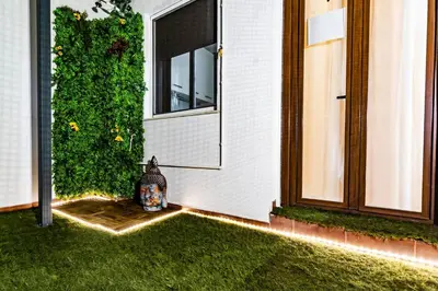 a vase sitting on the grass next to a house at SH Piluca's Home. Moderno apartamento con patio in Cádiz