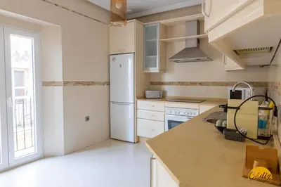 a kitchen with a white refrigerator freezer next to a window at Balcones del Atlantico - FREE PARKING by Cadiz Time in Cádiz