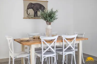 a dining room table with white chairs and an elephant picture on the wall at Balcones del Atlantico - FREE PARKING by Cadiz Time in Cádiz