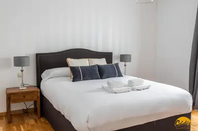 a bedroom with a large bed with two towels on it at Balcones del Atlantico - FREE PARKING by Cadiz Time in Cádiz