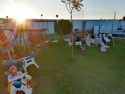 a backyard with a playground with swings and play equipment at Chiclana El Principito in Chiclana de la Frontera