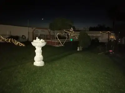 a white fire hydrant in a yard at night at Chiclana El Principito in Chiclana de la Frontera
