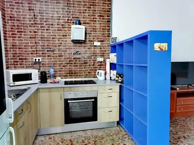 a kitchen with blue cabinets and a brick wall at Chiclana El Principito in Chiclana de la Frontera