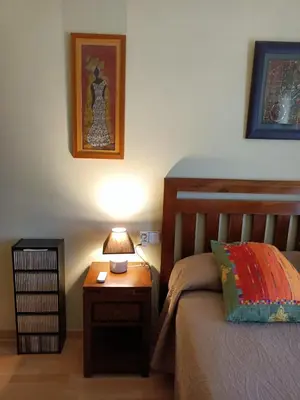 a bedroom with a bed and a table with a lamp at Apartamento la Concha in Chiclana de la Frontera