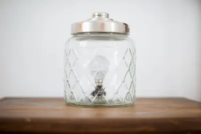 a glass jar with a candle on a wooden table at La Casa Morada in Cádiz