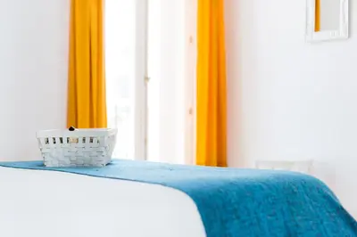 a bed with a blue blanket and a basket on it at La Casa Morada in Cádiz