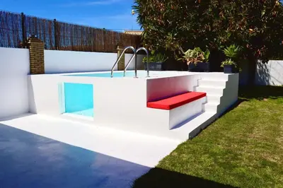 a swimming pool with a bench in a backyard at Apartamento “Las Cuadras “ in Cádiz