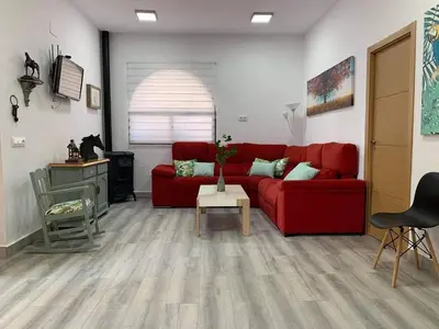 a living room with a red couch and a table at Apartamento “Las Cuadras “ in Cádiz