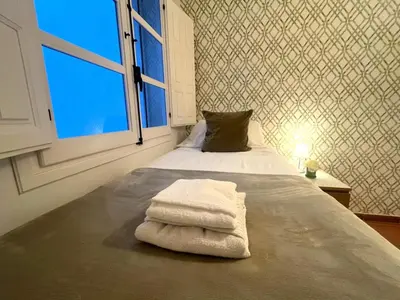 a bedroom with a bed with towels on it at Apartamento La Laja 5 min de la playa in Cádiz