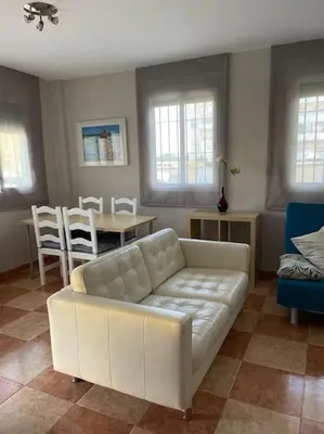 a living room with a white couch and a table at SlowHome Rota in Rota