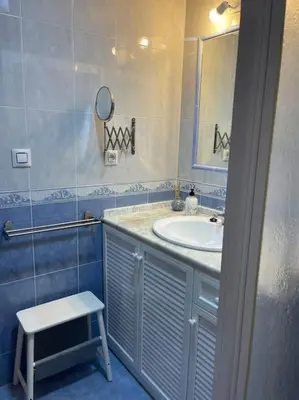 a bathroom with a sink and a stool and a mirror at SlowHome Rota in Rota