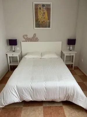 a bedroom with a large white bed with two tables at SlowHome Rota in Rota