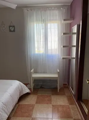 a bedroom with a bed and a window with a bench at SlowHome Rota in Rota