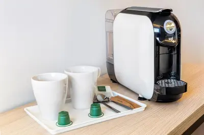 a coffee maker and two cups on a table at B&B HOTEL Jerez in Jerez de la Frontera
