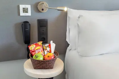 a basket of fruit on a table next to a bed at B&B HOTEL Jerez in Jerez de la Frontera