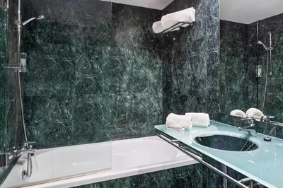 a bathroom with a bath tub and a sink at B&B HOTEL Jerez in Jerez de la Frontera