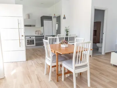 a living room with a wooden table and chairs at GuestReady - Blanca Paloma Ana in El Puerto de Santa María