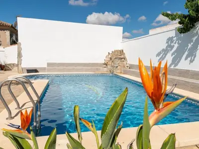 a swimming pool with orange flowers in front of a building at GuestReady - Blanca Paloma Ana in El Puerto de Santa María