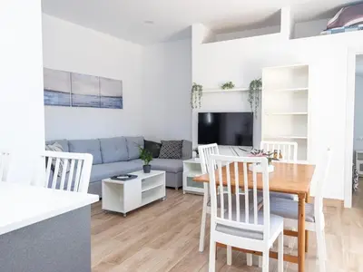 a dining room and living room with a table with a plate on it at GuestReady - Blanca Paloma Ana in El Puerto de Santa María