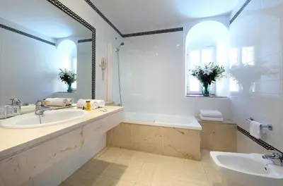 a bathroom with two sinks and a tub and a mirror at Crisol Monasterio de San Miguel in El Puerto de Santa María