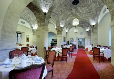 a dining room with tables and chairs in a building at Crisol Monasterio de San Miguel in El Puerto de Santa María