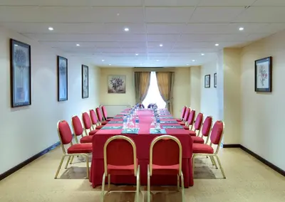 a conference room with a long table and red chairs at Crisol Monasterio de San Miguel in El Puerto de Santa María