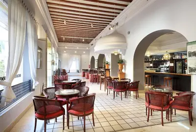 a restaurant with tables and chairs and a bar at Crisol Monasterio de San Miguel in El Puerto de Santa María
