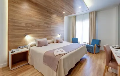 a bedroom with a large bed with a wooden wall at Hotel Monte Puertatierra in Cádiz