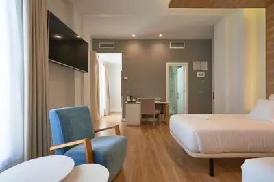 a hotel room with a bed and a chair at Hotel Monte Puertatierra in Cádiz