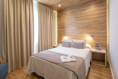 a hotel room with a bed with two towels on it at Hotel Monte Puertatierra in Cádiz