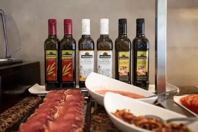 four bottles of wine sitting on a counter with meat at Hotel Monte Puertatierra in Cádiz